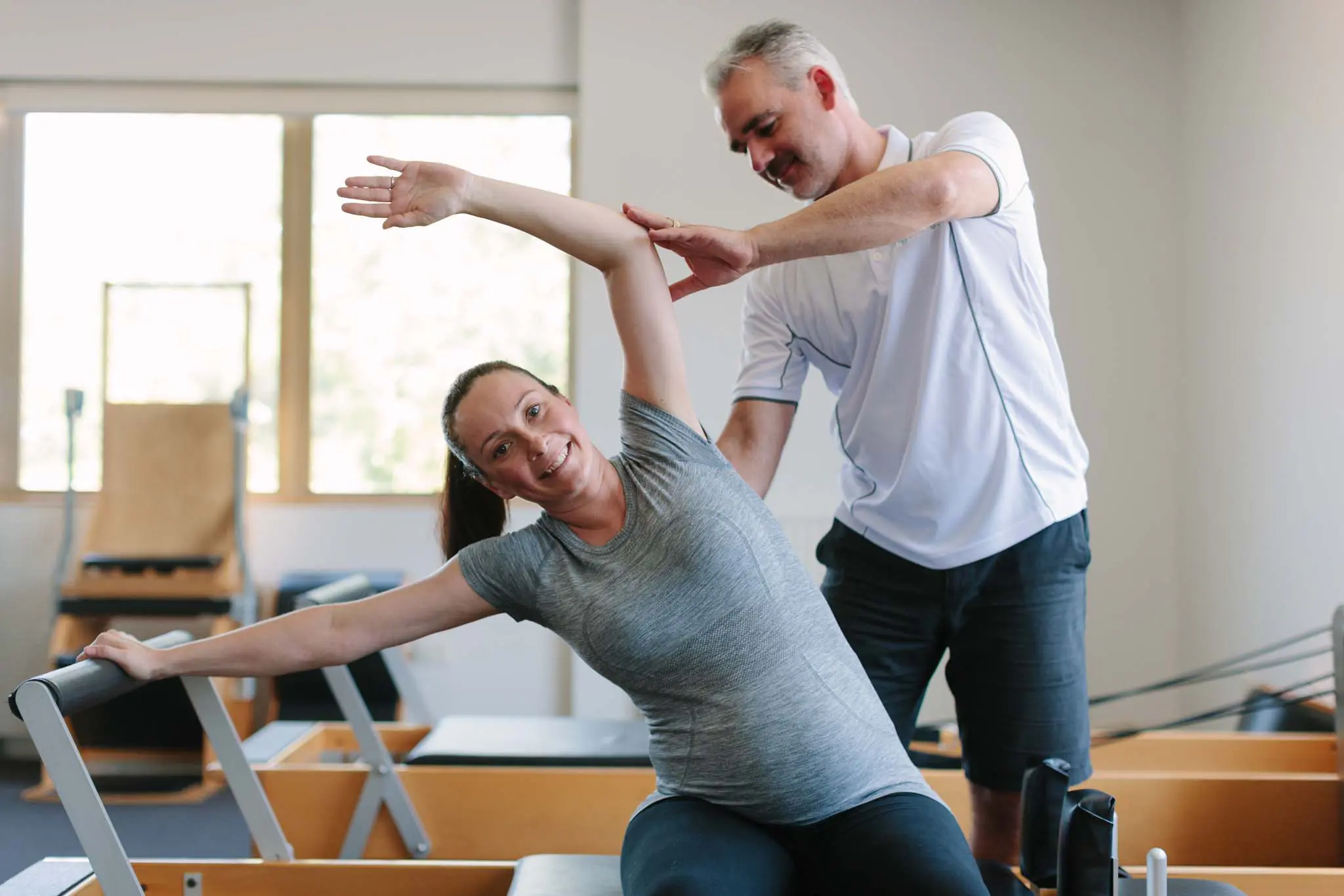 Instructor refining movement for Pregnant Client