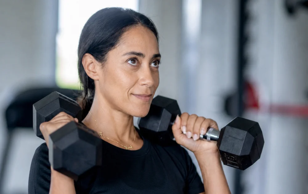 woman holding dumbbells to get stronger